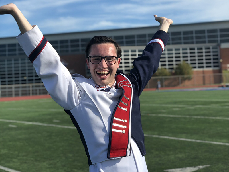 Matthew Zemba posing in band uniform on the football field in Seth Grove Stadium