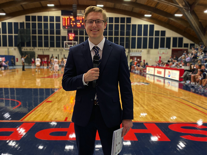 Tyler Dancisin posing with microphone inside crowded Heiges Field House