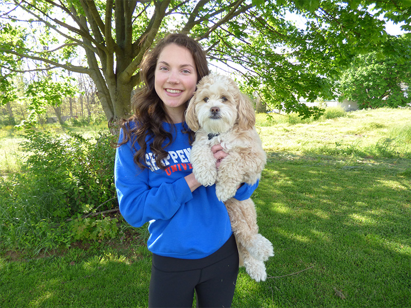 Mary Hykes wearing Shippensburg University shirt and holding small dog