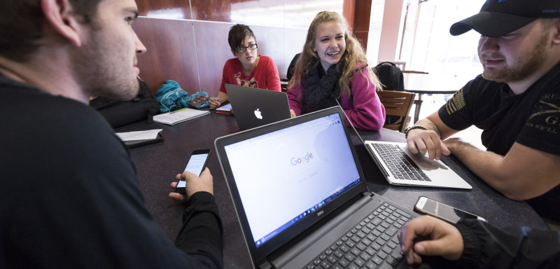 Photo of students gathered around laptops