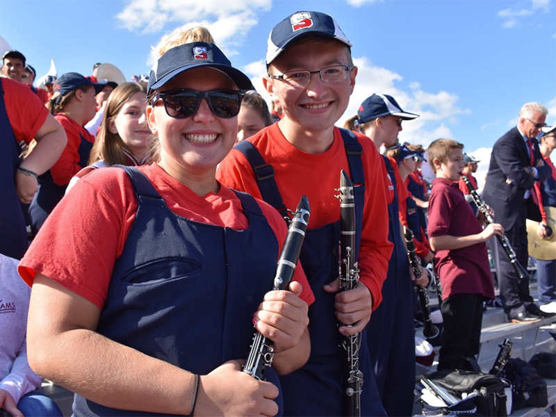 Clarinet players in Shippensburg University marching band pose in stands of Seth Grove Stadium