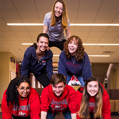 students in the cub in a cheerleader-style pyramid