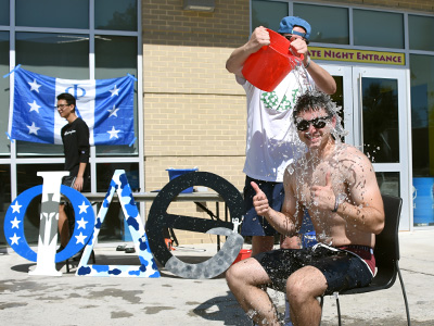 Student in chair bucket of ice over his head