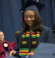 Student in cap and gown accepting diploma 