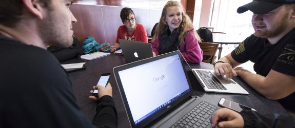 Photo of students gathered around laptops